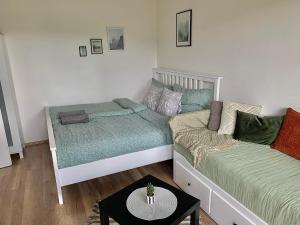 a room with two beds and a table in it at Apartmánek Protěž in Janske Lazne