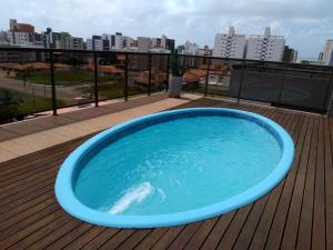 une baignoire bleue assise au-dessus d'une terrasse dans l'établissement Apartamento confortavel com piscina em Intermares, à Cabedelo