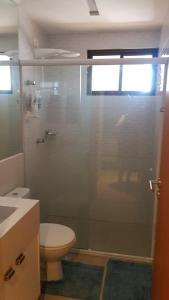 La salle de bains est pourvue de toilettes et d'une douche en verre. dans l'établissement Apartamento confortavel com piscina em Intermares, à Cabedelo