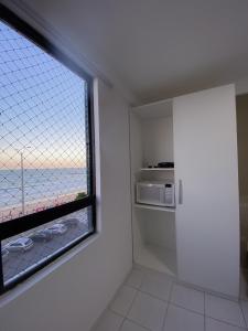 a kitchen with a window with a view of the ocean at Acomodação aconchegante à beira- mar in Natal