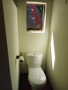 a small bathroom with a toilet and a window at La Tiaré île aux Nattes in Sainte Marie
