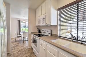 a kitchen with white cabinets and a sink and a window at Furnished Patio and Mtn View Palm Desert Retreat in Palm Desert