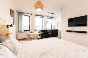 1 dormitorio con cama y mesa pequeña en Urban Condo en Liepāja