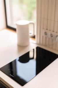 a tablet sitting on a counter with a cup on it at Urban Condo in Liepāja +18 photos