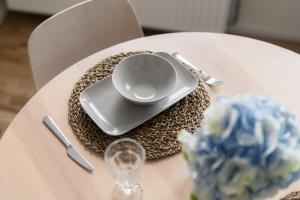 a table with a plate and a glass on it at Urban Condo in Liepāja