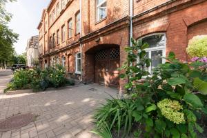 a brick building with a door on a street at Urban Condo in Liepāja