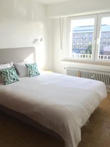una camera da letto con un grande letto bianco con due cuscini di Rosegaertchen a Lussemburgo