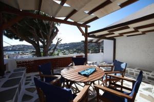 einen Holztisch und Stühle auf einer Terrasse in der Unterkunft St George Studios & Apartments in Batsi