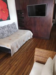 a bedroom with a bed and a flat screen tv at Casa Macondo Bed & Breakfast in Cuenca
