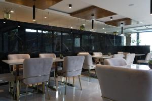 a dining room with tables and chairs and windows at Casa Cuarzo Hotel Boutique in Zacatecas