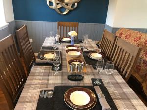 a long table with plates and glasses on it at No. 6 - the little house that gives you a hug in Trumpan