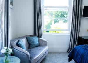 a living room with a chair and a window at Gresham Court in Torquay