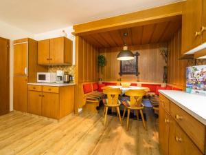 una cocina con armarios de madera, mesa y sillas en Beim Zuntl I, en Ehrwald