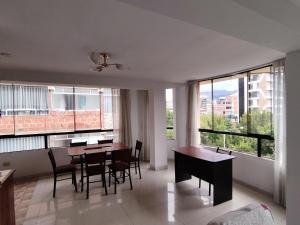 - un salon avec une table, des chaises et des fenêtres dans l'établissement WASYCHACUSCO, à Cusco