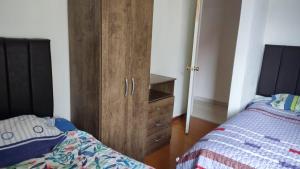 - une chambre avec une armoire en bois à côté d'un lit dans l'établissement WASYCHACUSCO, à Cusco