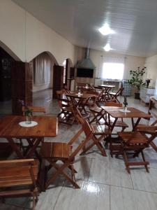 een groep tafels en stoelen in een kamer bij Pousada Belvedere in Tibagi