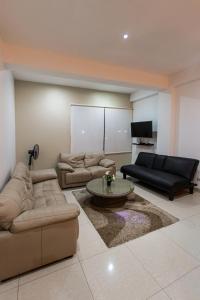 a living room with couches and a table and a tv at El Paraíso Eco Resort in Pisco