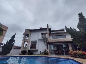 a house with a swimming pool in front of it at Pousada & Hostel Boca da Barra in Itanhaém