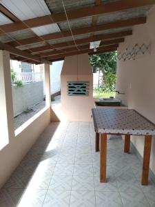 eine Terrasse mit einem Tisch und einem Kamin in der Unterkunft Casa na Pinheira, Praia de Cima in Pinheira