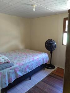 ein Schlafzimmer mit einem Bett und einem Ventilator in der Unterkunft Casa na Pinheira, Praia de Cima in Pinheira