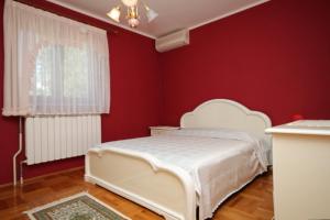Schlafzimmer mit einem weißen Bett und roten Wänden in der Unterkunft Holiday house with a parking space Krsan - Vlasici, Central Istria - Sredisnja Istra - 7685 in Kršan + 22 Fotos