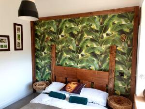 a bedroom with a mural of leaves on the wall at Luxury Oriental Home with Exotic Garden & Free Parking in West Derby