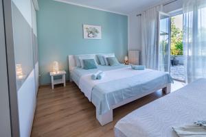 a blue bedroom with two beds and a balcony at Apartments by the sea Lovran, Opatija - 7837 in Lovran
