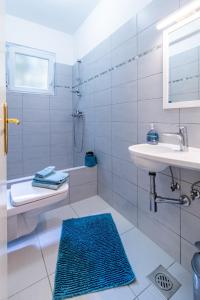 a white bathroom with a sink and a shower at Apartments by the sea Lovran, Opatija - 7837 in Lovran