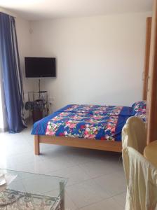 um quarto com uma cama com um edredão colorido e uma televisão em Studio Icici 7785a em Ičići