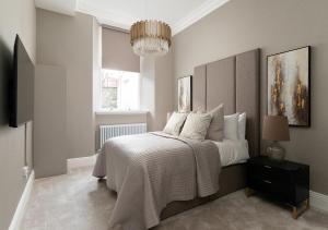 a bedroom with a bed and a chandelier at Luxury Georgian City Retreat With Hot Tub & Patio in Edinburgh