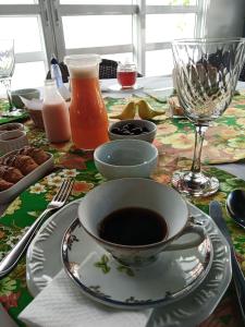 una mesa con una taza de café y un plato de comida en Pousada Belvedere, en Tibagi