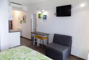 una habitación con una cama, una silla y una mesa en Studio Moscenice 7689a, en Mošćenička Draga