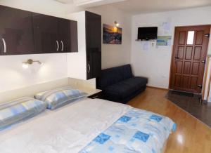 Un dormitorio con una cama grande y un sofá. en Studio Moscenice 7689b, en Mošćenička Draga