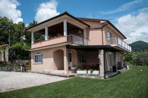a pink house with a balcony on top of it at Apartments with a parking space Opric, Opatija - 7726 in Opric