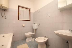 a white bathroom with a toilet and a sink at Apartments with a parking space Opric, Opatija - 7726 in Opric