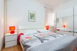 a bedroom with a bed and two night stands and two lamps at Apartments with parking space Medulin - 7657 in Medulin