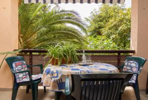 a table and chairs on a balcony with a plant at Apartments with parking space Medulin - 7657 in Medulin +27 photos