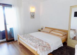 Un dormitorio con una cama y una ventana grande. en Studio Moscenice 7689c, en Mošćenička Draga