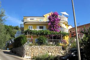 a yellow house with flowers on the side of it at Apartments with a parking space Medveja, Opatija - 7721 in Medveja