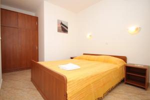 メドヴェヤにあるApartments with a parking space Medveja, Opatija - 7721のベッドルーム1室(ベッド1台付)、木製キャビネットが備わります。