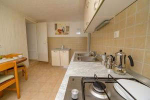 a kitchen with a sink and a stove top oven at Apartment Nerezine 7963b in Nerezine