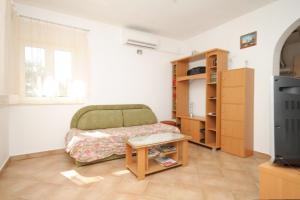 a room with a bed and a table and a tv at Holiday house with a parking space Veprinac, Opatija - 7699 in Veprinac