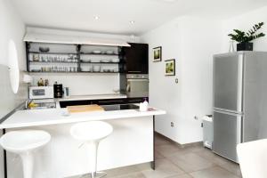 a kitchen with a white counter and a refrigerator at Luxury villa with a swimming pool Opatija - Pobri, Opatija - 7843 in Matulji
