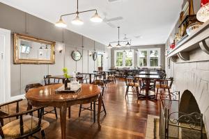 een restaurant met tafels en stoelen en een open haard bij The Bundanoon Guest House in Bundanoon