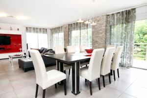 a dining room with a black table and white chairs at Luxury villa with a swimming pool Opatija - Pobri, Opatija - 7843 in Matulji
