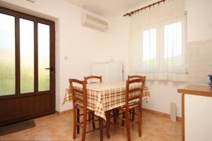 a kitchen with a table and chairs in a room at Apartments with a parking space Cres - 7994 in Cres