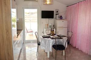 a dining room with a table and a pink curtain at Apartments with a parking space Ravni, Labin - 7674 in Ravni