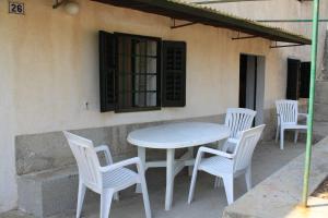 un tavolo bianco e sedie seduti accanto a un edificio di Holiday house with WiFi Stivan, Cres - 7995 a Štivan
