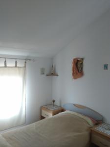 a bedroom with a bed and a window at Apartments with a parking space Cunski, Losinj - 8010 in Cunski