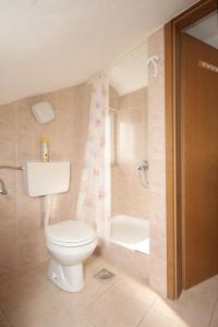 a bathroom with a toilet and a bath tub at Holiday apartments Osor, Losinj - 8004 in Nerezine